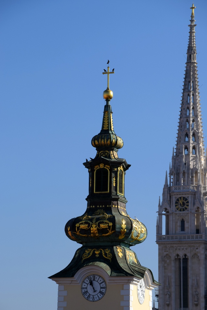 El campanario verde y dorado de la Iglesia de Santa María y detrás, una de las torres de la Catedral